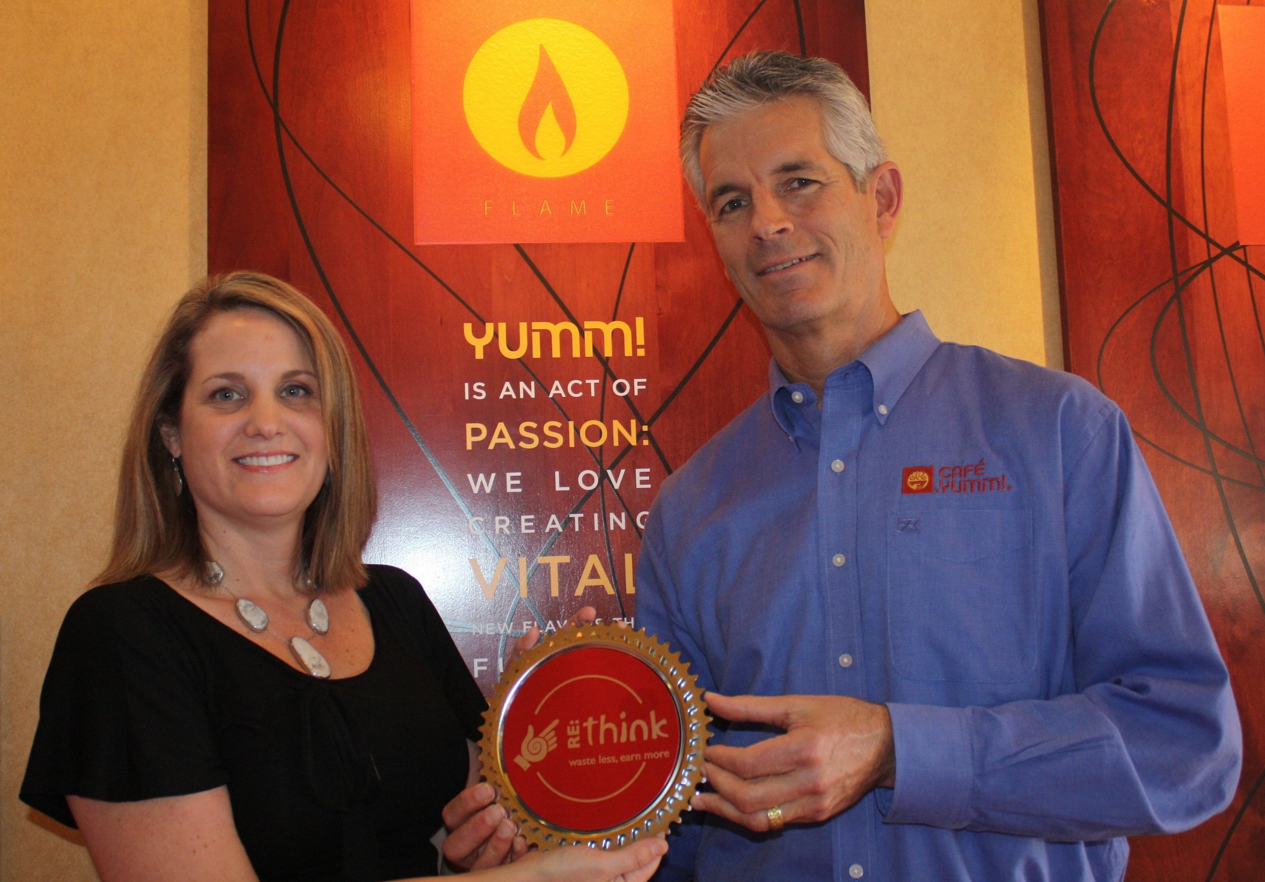 Cafe Yumm accepts re:think Certified Busness Award for environmental business practices